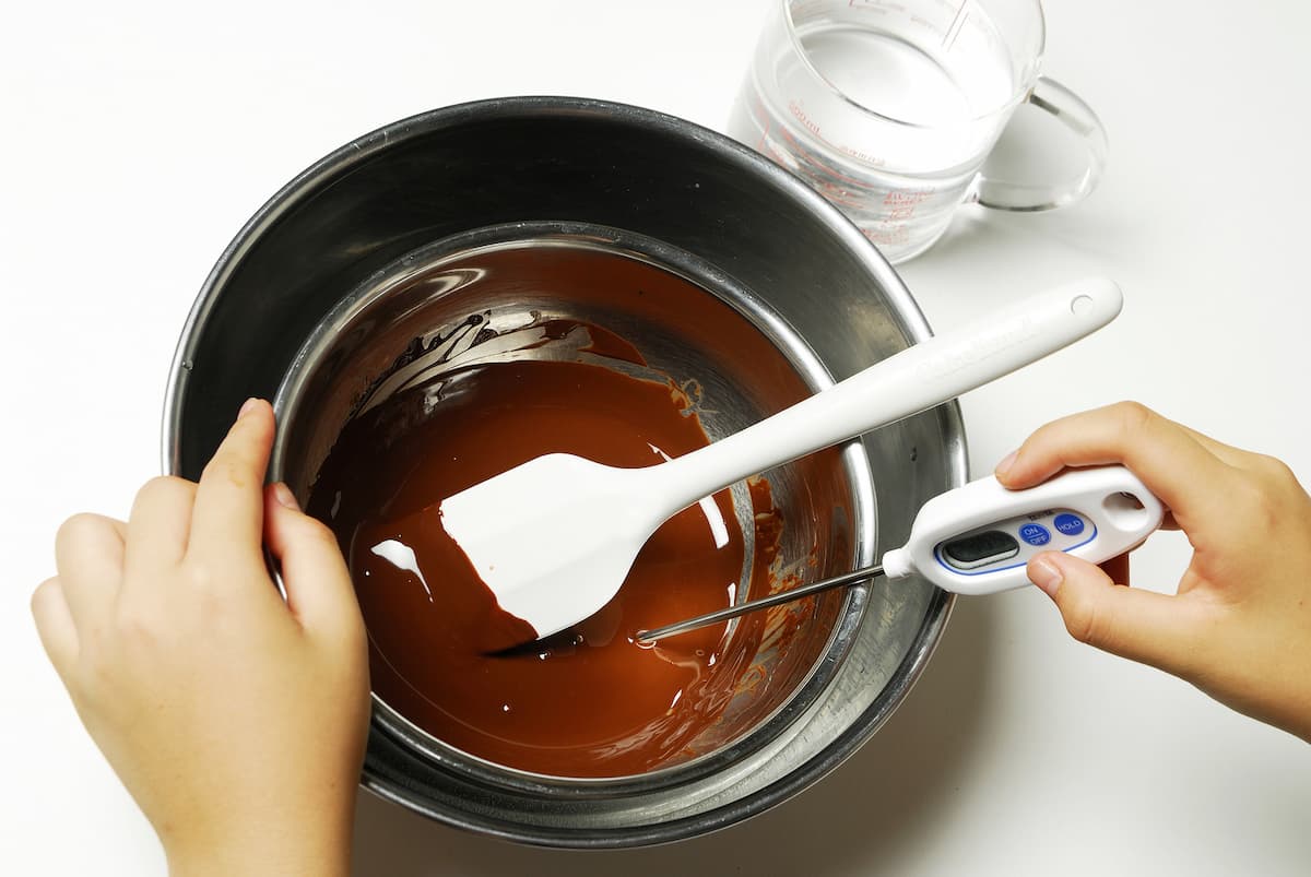 テンパリングのチョコレートを湯せんにかける作業