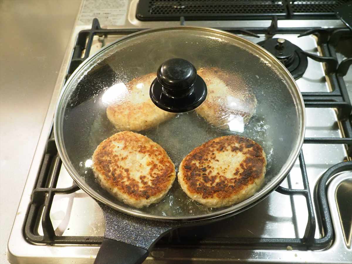 こんにちは、筋肉料理人です。今日は鶏ひき肉と豆腐を使った塩ハンバーグレシピを紹介させて頂きます。鶏ひき肉と豆腐を使うので合いびき肉より材料代が安く、ボリュームたっぷりに作っても豆腐なので低カロリー。お腹いっぱいになっても、食後感が軽いのがいいところです。そしてもちろんですが味も妥協無し、豆腐をたっぷり使いますが、いかにもハンバーグって味に仕上げます。

豆腐ハンバーグを美味しく作るコツですが、まずは豆腐の種類の選別です。豆腐にはソフト、絹、木綿、厚揚げ等幾つか種類があります。ソフト豆腐と絹豆腐は水分が多く、水切りしにくいので向いていません。木綿豆腐と厚揚げはどちらも水分量が少ないので向いていますが、厚揚げは油で揚げているので風味が強いです。ですので、今回は水分量が少なく、ハンバーグの風味に合う木綿豆腐を水切りして使いました。

そしてもう一つ、ハンバーグを美味しく作るコツなんですが、やっぱり炒め玉ねぎにつきると思います。玉ねぎを炒めてあめ色にし、玉ねぎの甘味をメイラード反応で旨味に変え、旨味と風味を入れる。これが大事でしょう。そして、今回は豆腐を使うので、その風味をどうするかです。豆腐の風味が何より好きって方はそのままでいいですが、ハンバーグ寄りが好きって方も多いでしょう。普通のハンバーグっぽい風味にする為、おろしにんにくを入れます。豆腐の風味は意外に強いので、にんにくの風味でマスクするわけです。


鶏ひき肉と豆腐の塩ハンバーグ

材料4人分
調理時間

鶏ひき肉　200g
木綿豆腐　1/2丁(200g)
玉ねぎ　1個(200g)
サラダ油　小さじ3
塩　適量

A
パン粉　大さじ6
マヨネーズ、片栗粉　各大さじ2
おろしにんにく　小さじ１/２
塩、鶏がらスープの素　各小さじ１/２
黒こしょう　小さじ1/３

作り方

１．木綿豆腐を大き目の皿にのせ、その上に皿をかぶせます。600mlのペットボトルに水を入れ、皿にのせて重しにして1時間、水切りします。
２．玉ねぎをみじん切りにし、サラダ油大さじ1/2を引いたフライパンに入れ、強めの中火で炒めます。5分程、焦げないように混ぜながら炒め、濃いめのあめ色になったら取り出して冷まします。※色づいてくると焦げやすくなるので、火加減を注意してください。炒めた後は金属製のバットに広げて入れると冷めやすいです。
３．ボウルに水切りした木綿豆腐を入れてつぶし、Aを入れて混ぜます。鶏ひき肉を加えて粘りが出るまで練ります。これを4等分し、小判型に形を整えて真ん中を凹まし、薄く小麦粉をまぶします。※Aのマヨネーズの効果でハンバーグがふっくら柔らかになります。タネを小判型に整えたら、クッキングシートの上に置くと、くっつかないので小麦粉をまぶしやすいです。小麦売をまぶして焼く事で、ジューシーさが増します。
４．フライパンにサラダ油大さじ1を引いて中火にかけ、3）のタネを入れて焼きます。2～3分焼いて焼き目がついたら返し、お湯1/4カップを入れてフタをし、5～6分、弱めの中火で蒸し焼きにします。蒸し焼きにしたらフタを外し、中火で焼いて水分を飛ばしたら出来上がりです。

皿に盛り付け、ブロッコリーとミニトマトを添え、皿の端に後付け用の塩を盛り付けます。

鶏ひき肉と豆腐の塩ハンバーグの完成です！
焼き目がついた見た目はハンバーグそのもの、表面はカリッとしていますが箸で切れる柔らかさです。塩ハンバーグなので最初はそのまま食べると焼き目の香ばしさを感じ、噛むと肉感と滑らかな食感があり、旨味のある塩味が口に広がります。肉の旨味と一緒に豆腐の風味がかすかに残る感じで、滑らかな食感で豆腐が入っているとわかる程度で、とても美味しいです。あと付けで塩をつけて食べると、はっきりした塩味が加わって味変し、ご飯、ビールがいける味になります。
豆腐が入っているので冷えても柔らかく、お弁当のおかずにもおすすめ。今回は主菜として作ったので、大きなハンバーグサイズにしていますが、タネを8等分、あるいは16等分にして焼き、それを冷凍して作り置き惣菜にするのもいいでしょう。鶏ひき肉と豆腐の塩ハンバーグをお試しください。