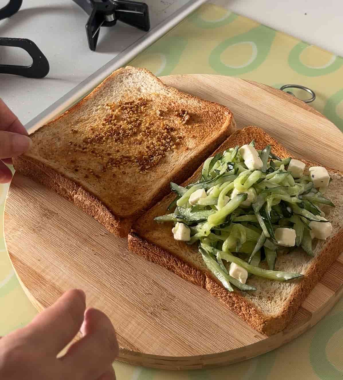 食パンにきゅうりをのせ軽く抑えカットする
