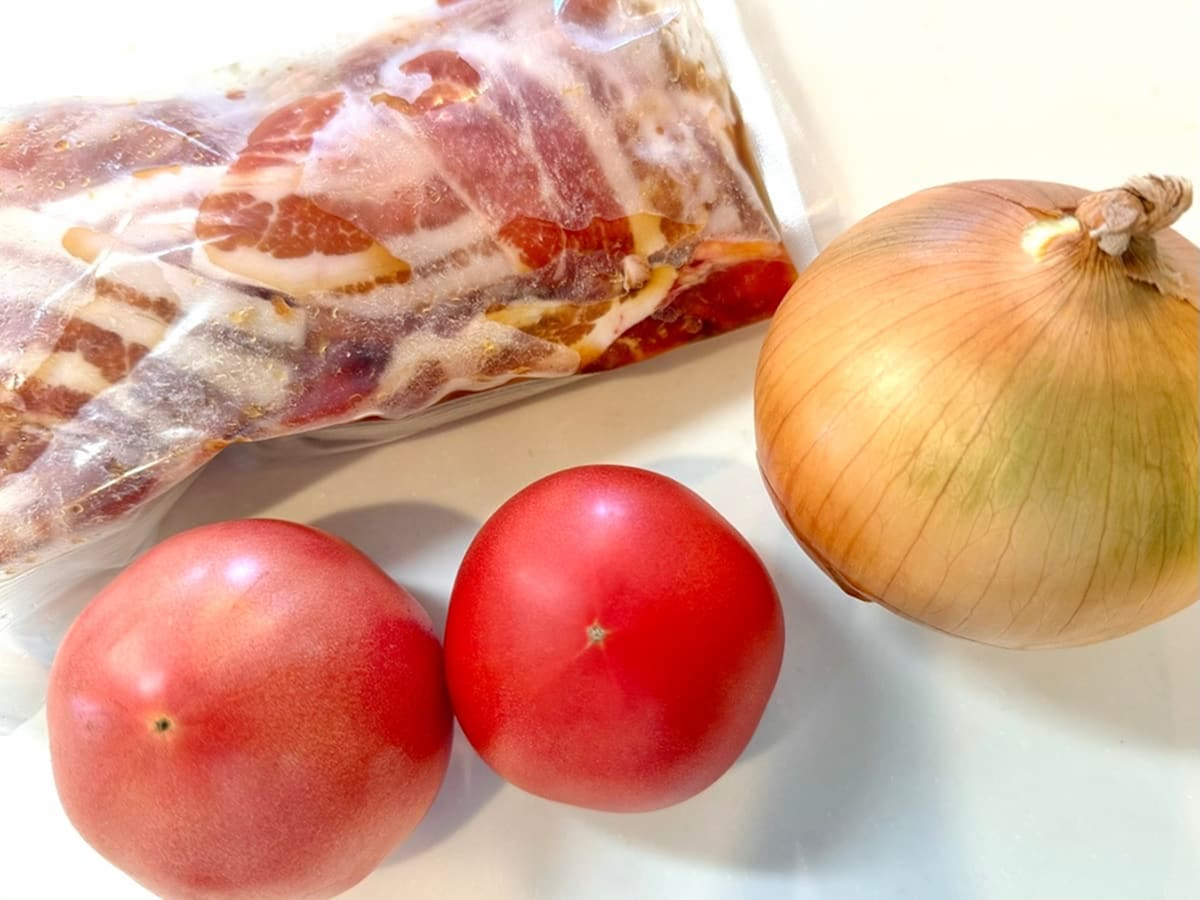 タレに付け込んだ豚バラ肉とトマトと玉ねぎが写った写真 トマトバターの洋風しょうが焼き まいのおやつ